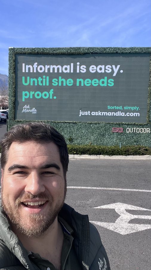 Ean in front of an AskMandla billboard